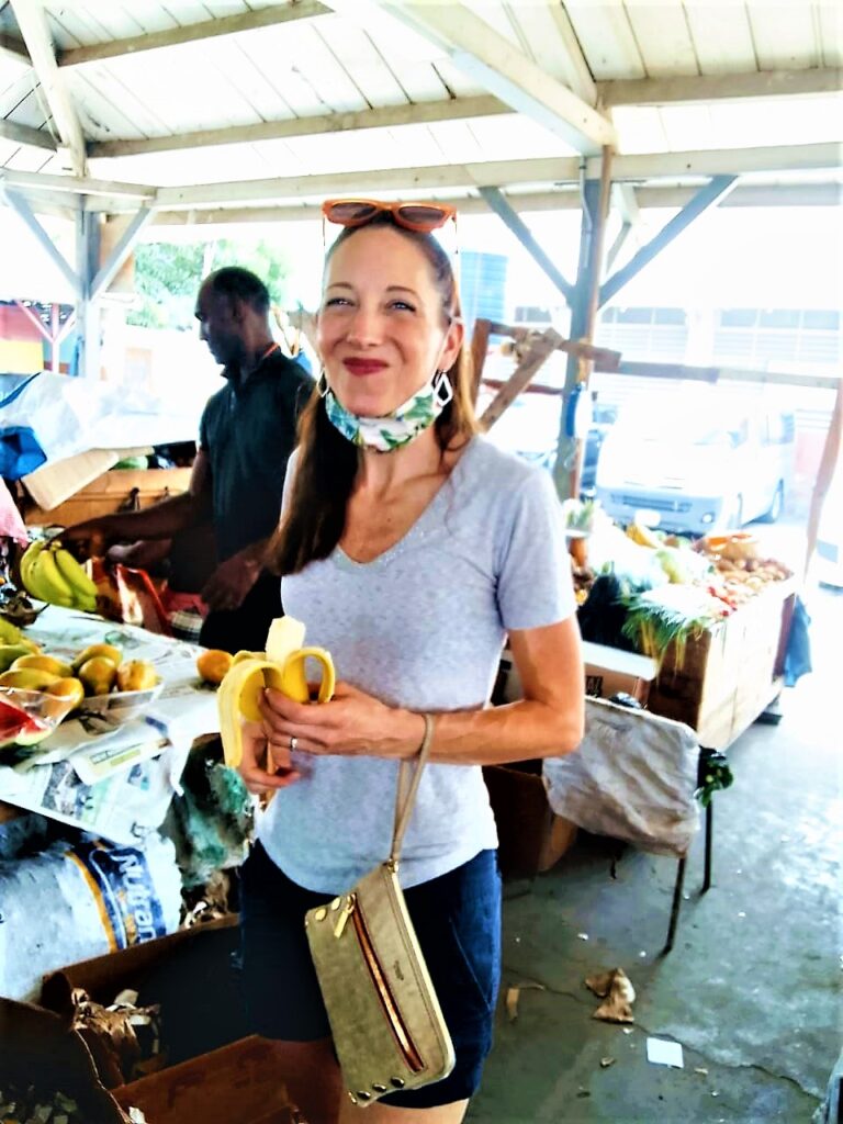 Visitor in market sampling banana on Jamaica Cultural Tours food tour